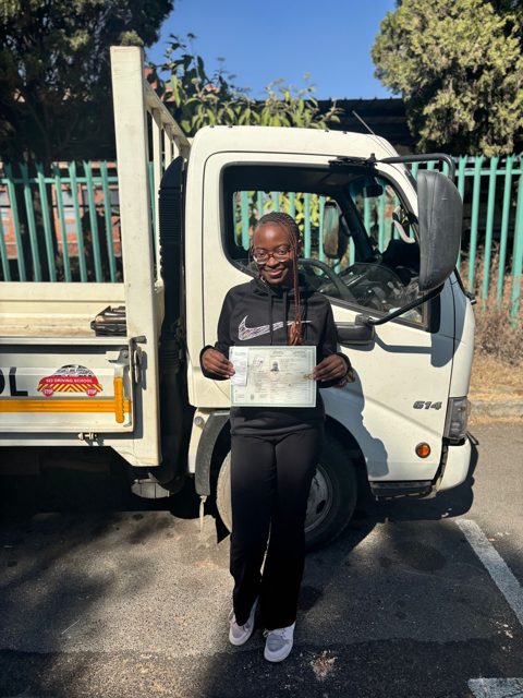 Learner with her licence beside a 522 truck